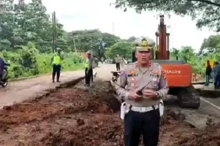Kasat Lantas Polres Pidie Iptu Mahruzar Hariadi saat melaporkan dari lokasi jalinsum KM 81 yang rusak parah dan amblas.