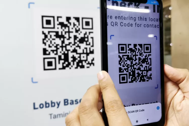 Pengunjung memindai kode QR melalui aplikasi PeduliLindungi sebelum masuk ke pusat perbelanjaan.  (ANTARA/Natisha Andarningtyas)
