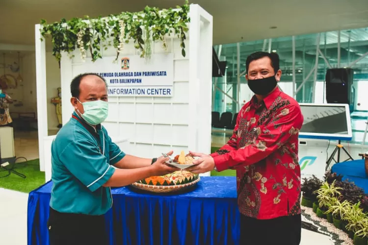 General Manager PT Angkasa Pura I Sepinggan Barata Singgih Riwahono menyerahkan potongan tumpeng pada petugas kebersihan Bandara Sepinggan Balikpapan. Bandara Sepinggan kembali menjadi bandara pemberi layanan terbaik tahun 2020. ( ANTARA/Novi Abdi)