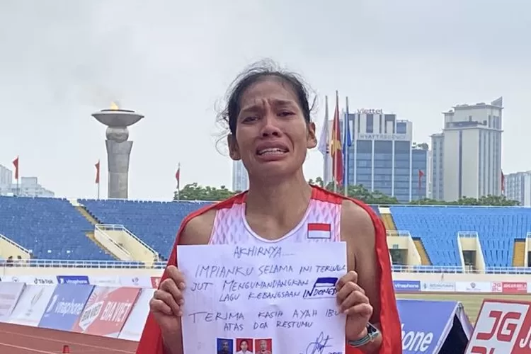  Pelari Indonesia Odekta Elvina Naibaho memegang kertas berisikan pesan sesaat setelah finis di urutan pertama sekaligus memastikan emas nomor marathon putri di Hanoi National Sports Complex, Stadion Nasional My Dinh, Hanoi, Vietnam, Kamis (19/5/2022). ( ANTARA/Arindra Meodia)