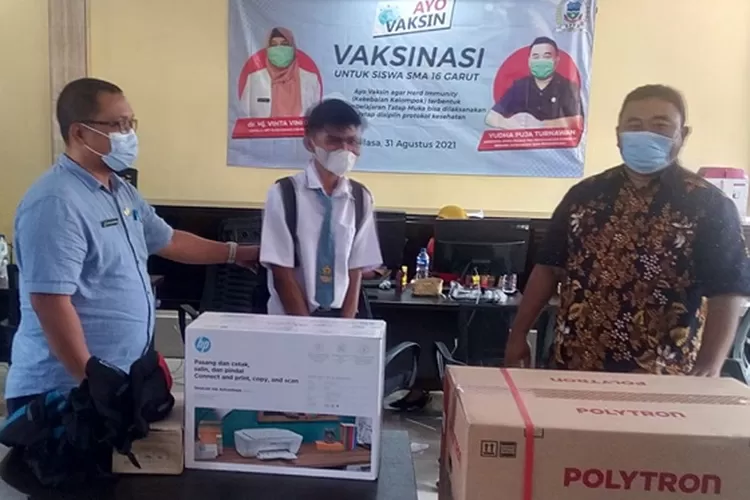Ketua Fraksi PDI Perjuangan DPRD Garut, Yudha Puja Turmawan, didampingi Kepala Sekolah SMA Negeri 16 Garut, Sopyan Nurjaman, menyerahkan hadiah berupa mesin cuci kepada Syahrul Sidik (18), siswa kelas XI SMAN 16 Garut, Selasa (31/8/2021).(Agus Alvin/Gorajuara.com)