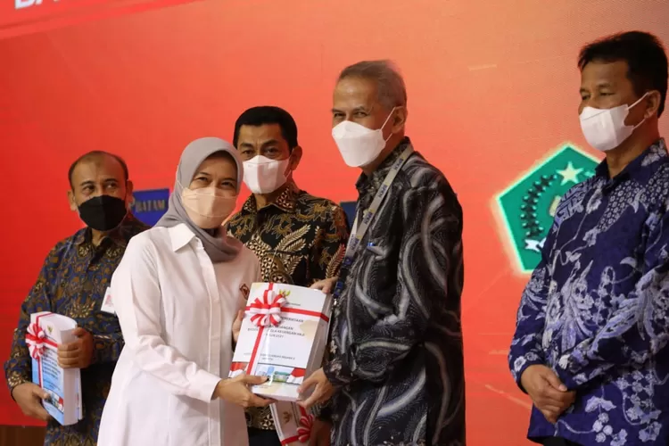 Serah terima laporan Hasil Pemeriksaan Laporan Keuangan BPKH dari Plt Anggota V BPK RI Isma Yatun kepada Kepala Badan Pelaksana BPKH Anggito Abimanyu.  (Dok BPKH)